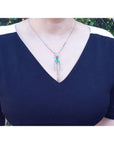 Marquise cut Colombian emerald necklace with diamond links in 14K white gold on a woman's chest.