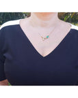 1.66 carat pear-cut natural emerald necklace in 14K yellow gold with a twig design.