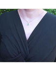 1.01 carat pear cut emerald necklace with accent diamonds on a 14K gold V chevron design.