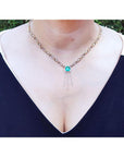 Emerald Kisses and Hugs necklace with a medium bluish green square emerald and gold X & O links.