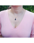Wello black opal pendant necklace with red-orange fire and blue-green flashes on a 14K yellow gold chain.