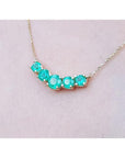 14K gold necklace with five round medium green Colombian emeralds in elegant basket settings.