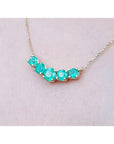 14K gold necklace with five round medium green Colombian emeralds in elegant basket settings.