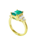 An emerald and accent side diamond ring side view.