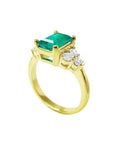 14K yellow gold ring with a rectangular emerald-cut deep bluish-green emerald and three accent diamonds on each side.