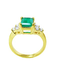 14K yellow gold ring with a rectangular emerald-cut deep bluish-green emerald and six accent diamonds.