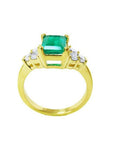 14K yellow gold ring with a rectangular emerald-cut deep bluish-green emerald and six accent diamonds.