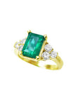 14K yellow gold ring with a rectangular emerald-cut deep bluish-green emerald and three accent diamonds on each side.