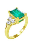 On a side profile view a 14k yellow gold emerald ring for women.