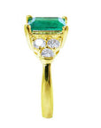 A Muzo Colombian emerald ring displaying its top, shoulder and band side profile.