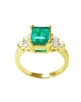 14K yellow gold women's ring with a rectangular emerald-cut deep bluish-green emerald and six accent diamonds.