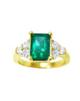 A women's emerald ring with accent side diamonds crafted in 14k yellow gold.