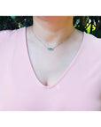0.68 ct Colombian emerald and diamond paper clip necklace in 18K white gold on a model.