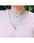 0.68 ct Colombian emerald and diamond paper clip necklace in 18K white gold on a model.