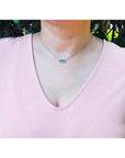0.68 ct Colombian emerald and diamond paper clip necklace in 18K white gold on a model.