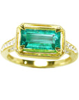 The frontside of this emerald ring displays the centered gemstone top and side's view perspective