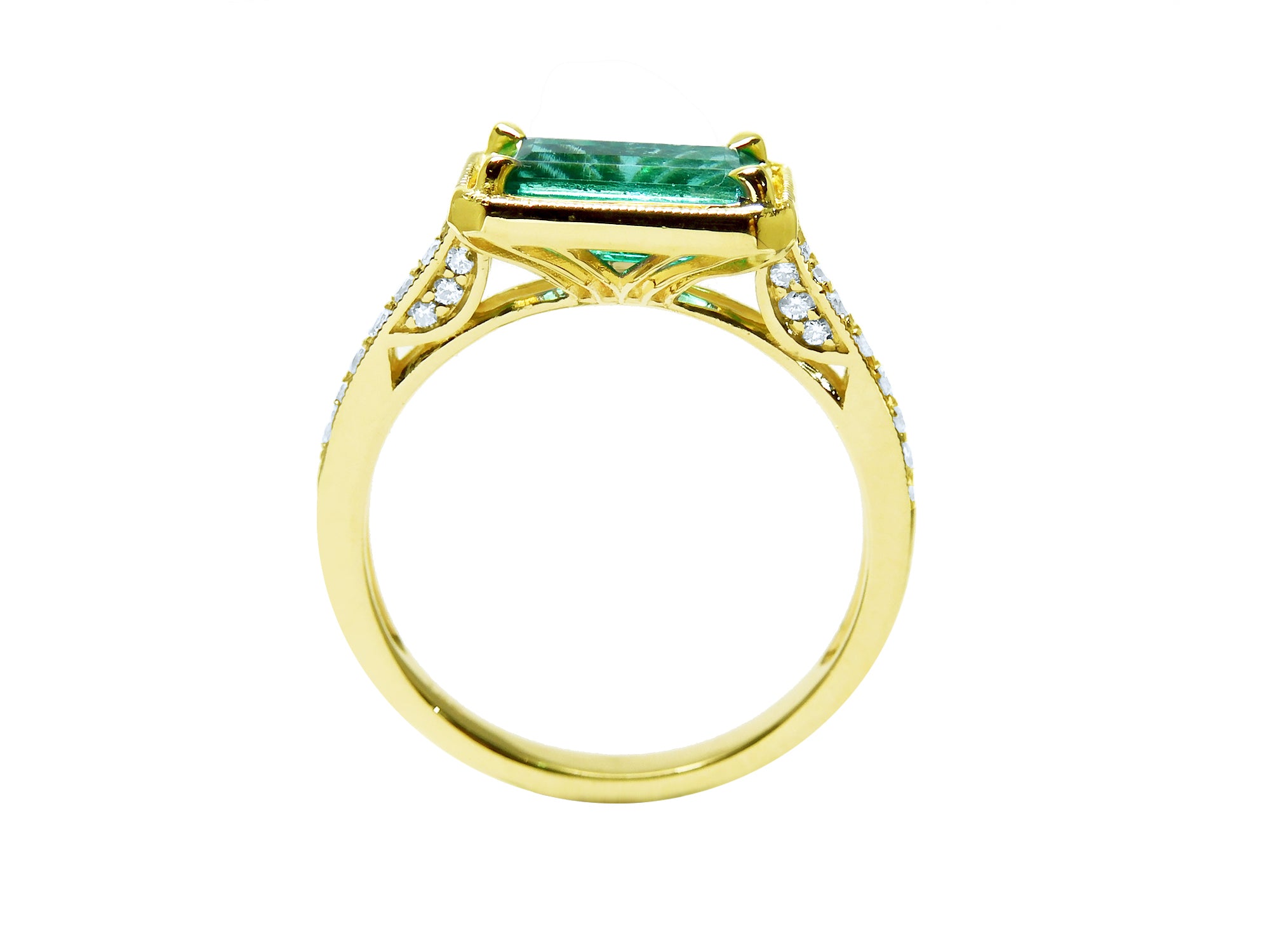 The lateral position of this emerald ring displays the top setting, gallery and band profile.