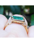 1.30 carat emerald-cut Colombian emerald ring in 14K yellow gold, east-west style with diamond accents.