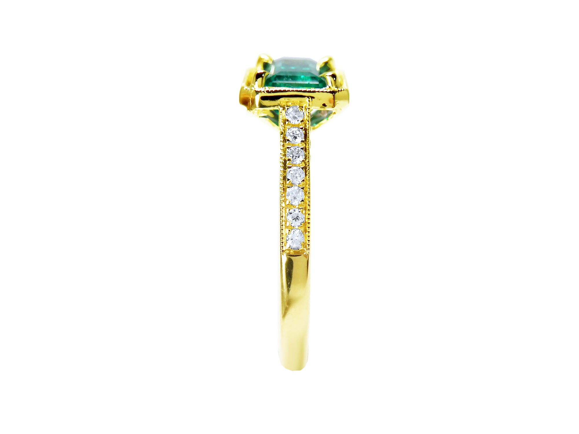 The side perspective of this emerald ring highlights the design details of its top setting, gallery, and band profile.