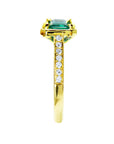 The side perspective of this emerald ring highlights the design details of its top setting, gallery, and band profile.