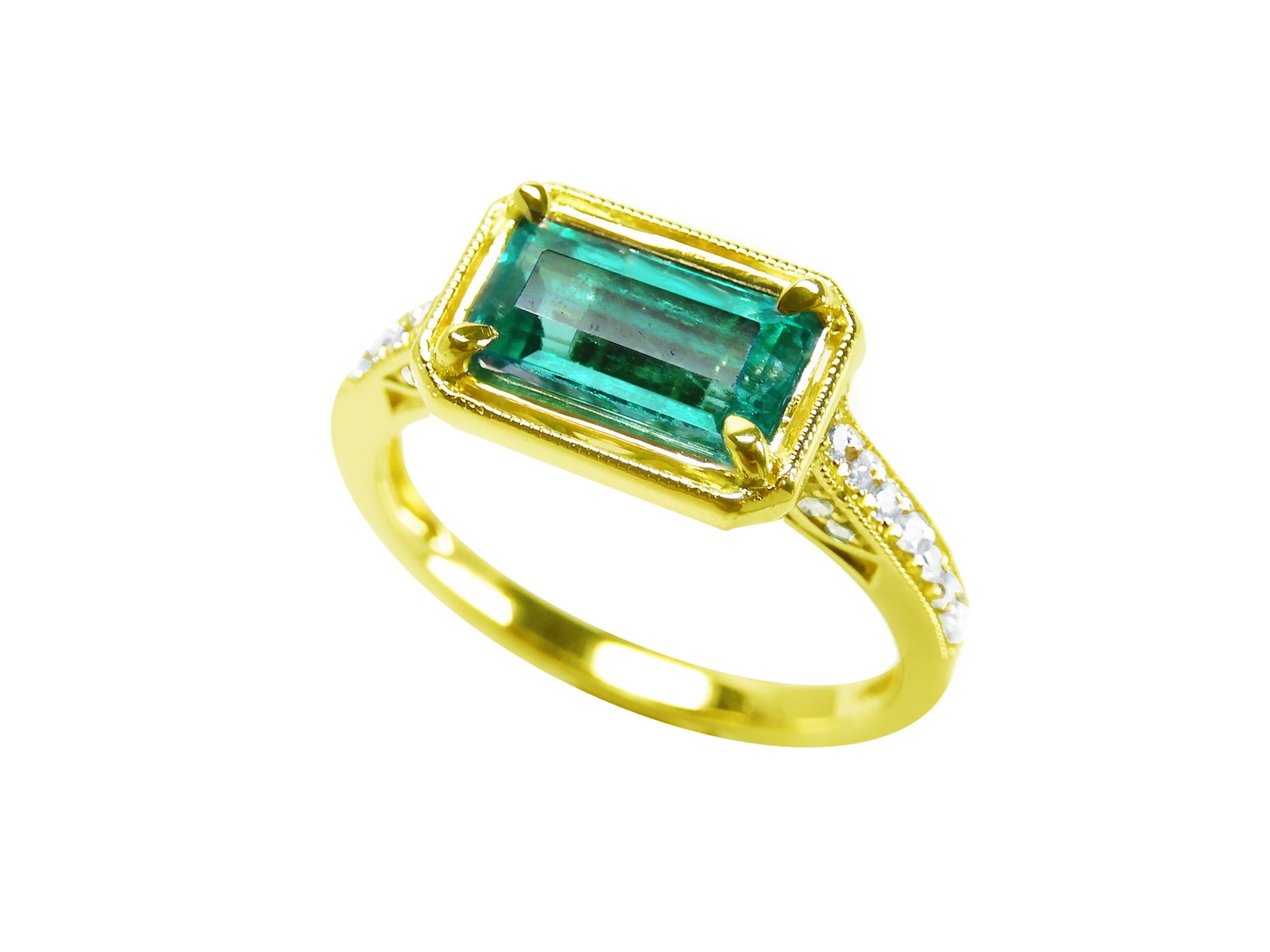 The tilted position of this natural emerald ring showcases the top centered gemstone and sides perspectives.