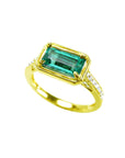 The tilted position of this natural emerald ring showcases the top centered gemstone and sides perspectives.