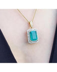 18K yellow gold emerald pendant with a rectangular emerald-cut stone and double halo natural diamonds.