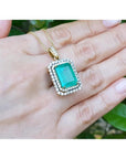 18K yellow gold emerald pendant with a rectangular emerald-cut stone and double halo natural diamonds.