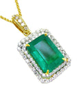 A yellow gold emerald pendant displaying the topside rectangular emerald surrounded by a double halo diamond.