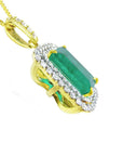 The underside profile view of a yellow gold pendant with a natural emerald and diamonds on a white background