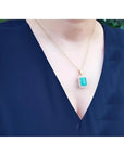 18K yellow gold emerald pendant with a rectangular emerald-cut stone and double halo natural diamonds.