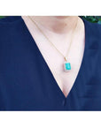 18K yellow gold emerald pendant with a rectangular emerald-cut stone and double halo natural diamonds.