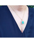 18K yellow gold emerald pendant with a rectangular emerald-cut stone and double halo natural diamonds.