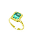 The tilted position of this emerald solitaire ring shows the top gemstone encased in wide bezels and shank profile.