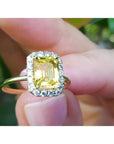 14K yellow gold ring with emerald-cut natural yellow sapphire and diamond halo.