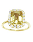 A natural yellow sapphire ring for women, featuring a vibrant canary yellow hue, set in a halo of diamonds on 14k gold.
