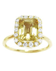 A natural yellow sapphire ring for women, featuring a vibrant canary yellow hue, set in a halo of diamonds on 14k gold.