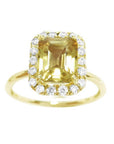 A natural yellow sapphire ring for women, featuring a vibrant canary yellow hue, set in a halo of diamonds on 14k gold.