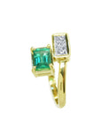 A 18k yellow gold toi et moi or you and me ring with a rectangular colombian emerald emerald-cut on one side and princess cut diamonds.