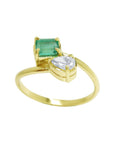 A yellow gold toi et moi ring featuring a rectangular emerald-cut gemstone and a pear-cut diamond.