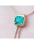 Emerald-cut natural Muzo Colombia emerald lariat necklace in 14K gold with milgrain detail on a box chain.