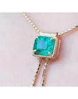 Emerald-cut natural Muzo Colombia emerald lariat necklace in 14K gold with milgrain detail on a box chain.
