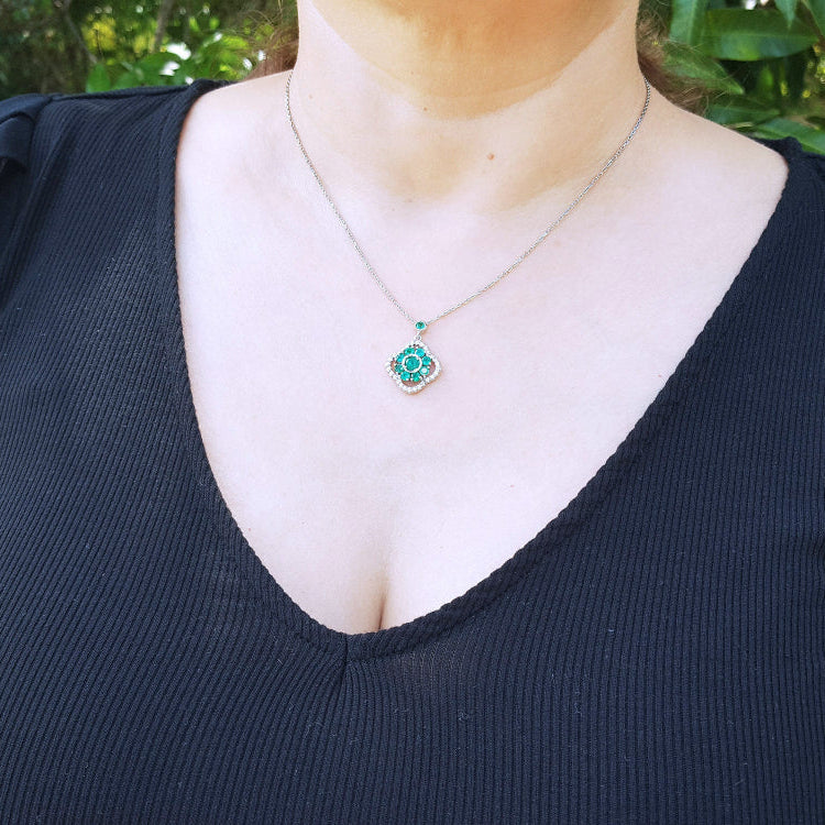 Round cut cluster emerald necklace, set within a delicate 4-leaf clover design accented by natural diamonds, crafted in 14k white gold