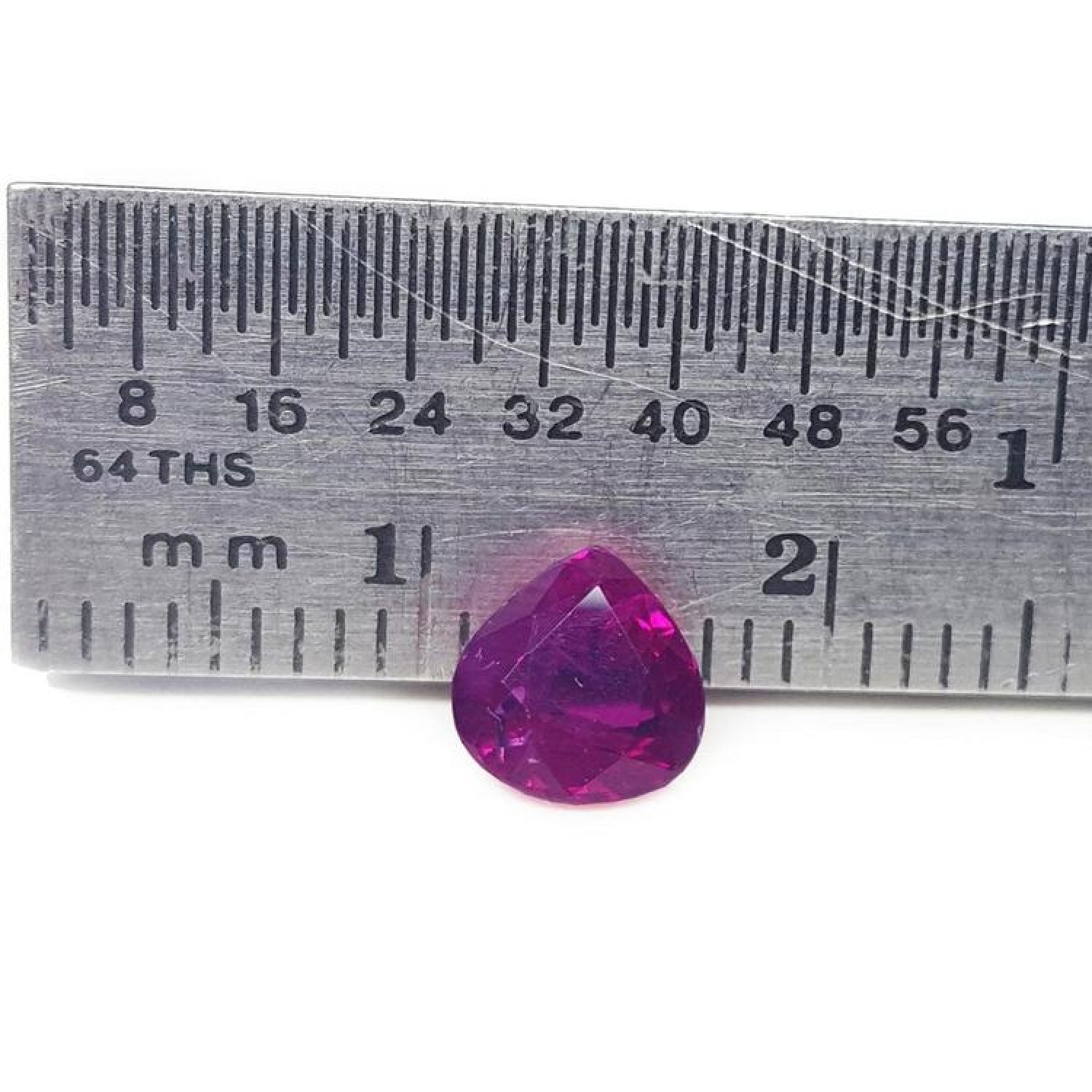 1.19 carat pear cut natural ruby loose gemstone with sparkling red color, measured by a ruler.