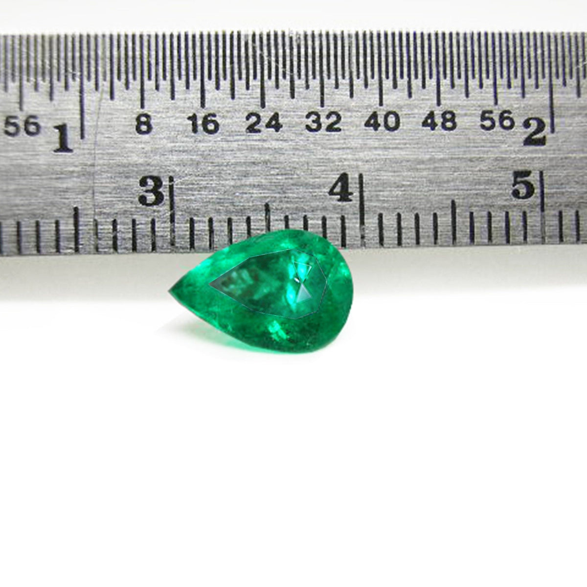 Natural colombian emerald pear cut, front side table and crown view next to a ruler for measure size