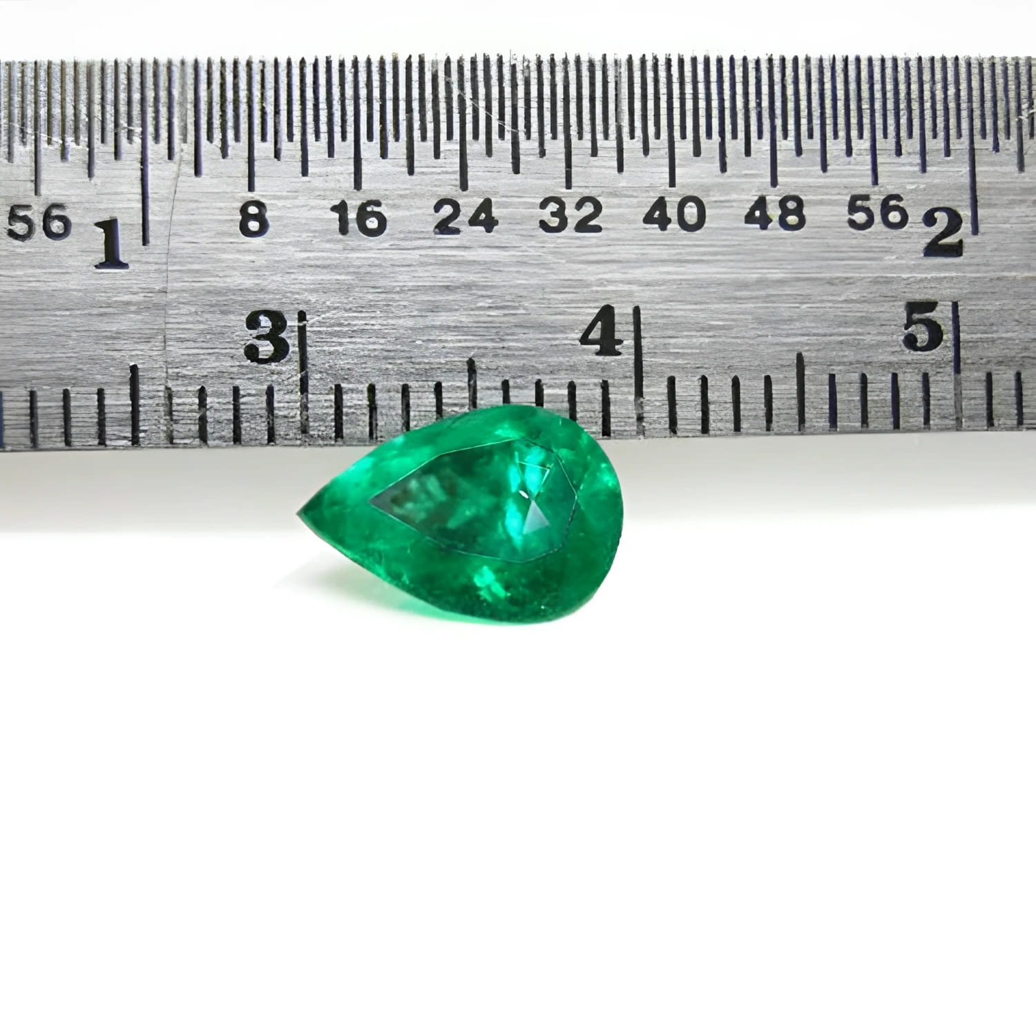 1.44 carat natural pear-cut Colombian emerald with a vibrant medium-deep green hue, shown next to a ruler.