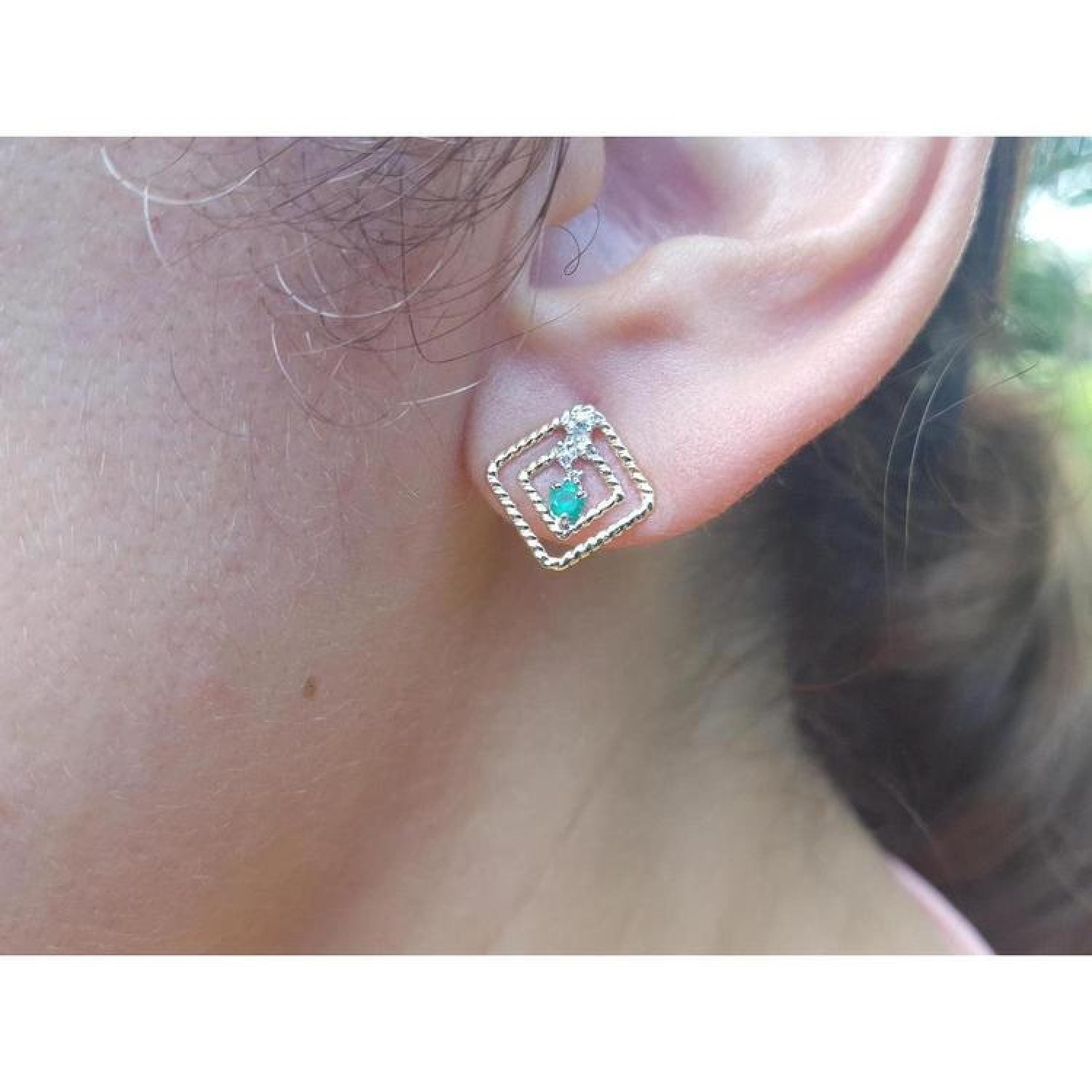 Women's 14K yellow gold braided geometric stud earring with a deep green emerald and clear stone.