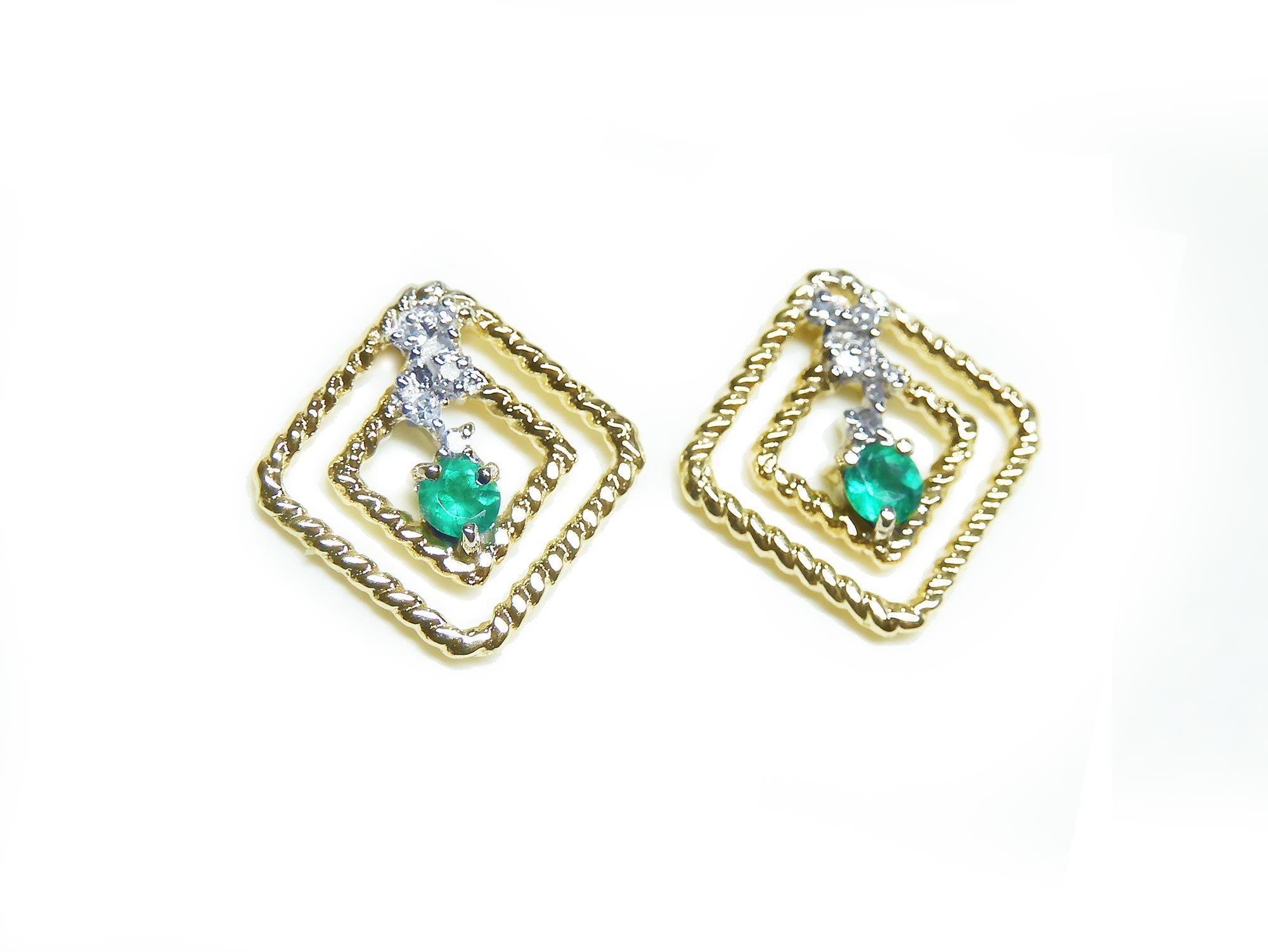 A pair of 14K yellow gold emerald post earrings with round cut Colombian emeralds set in a double frame rope decoration.