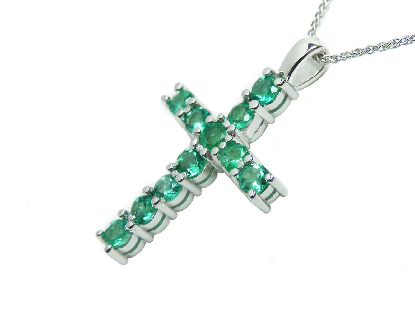 A Colombian emerald cross pendant necklace on a side position top and gallery shown.