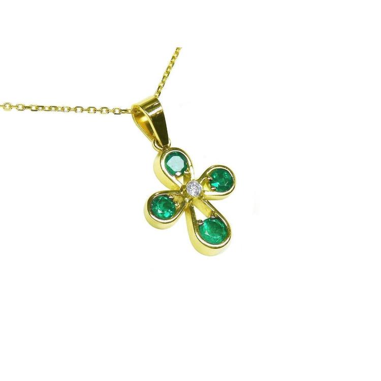 Gold necklace with a crossr-shaped pendant featuring natural emeralds on a right-side top position view.